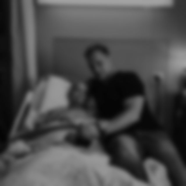 The author sitting on a hospital bed, holding his mother's hand
